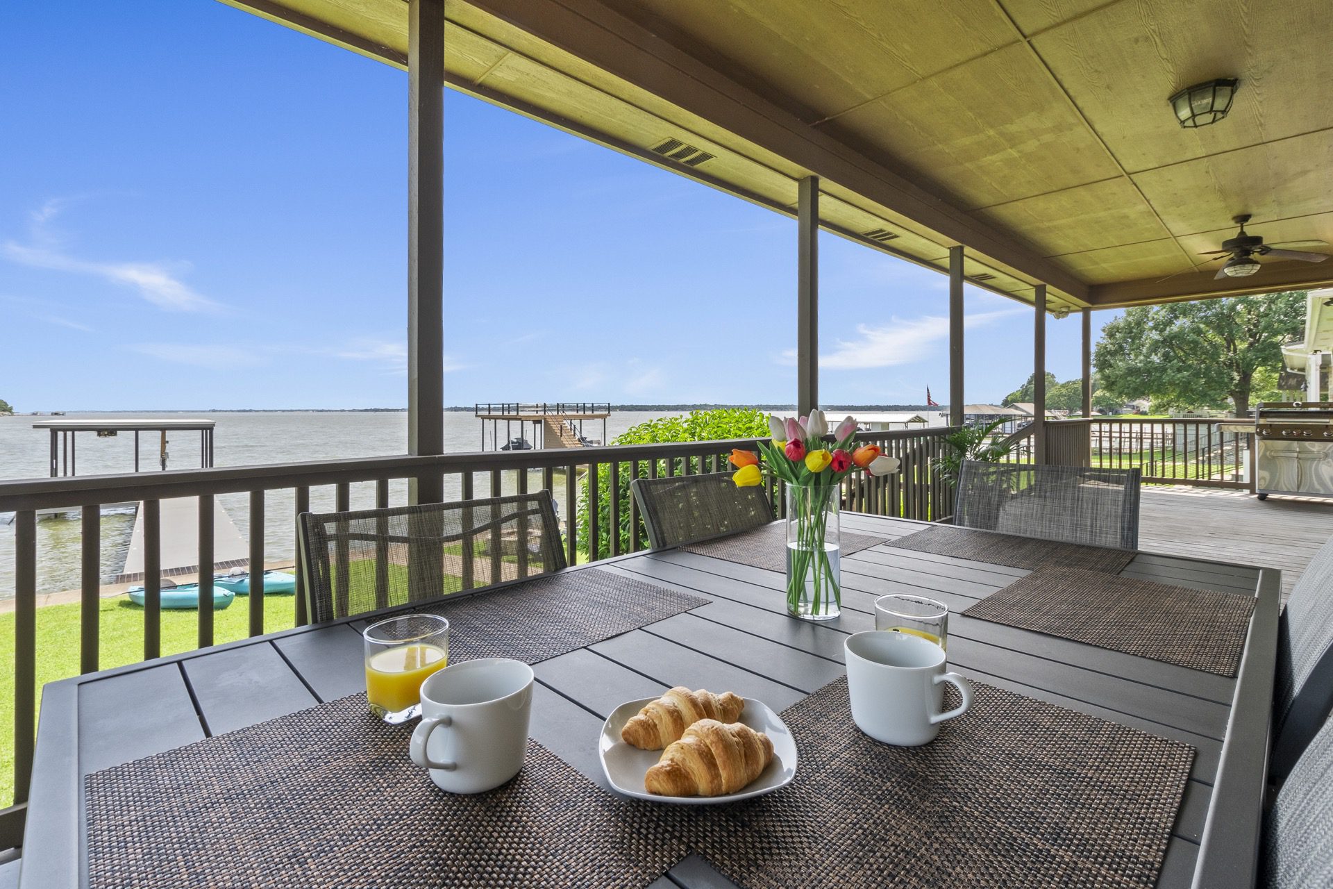 Massive covered porch with dining table, chairs and a grill.