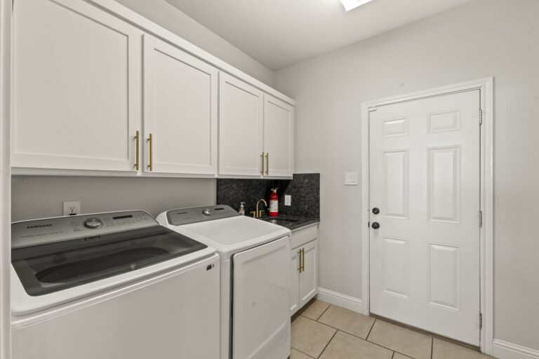 Convenient laundry room equipped with full-size washer and dryer for effortless living.