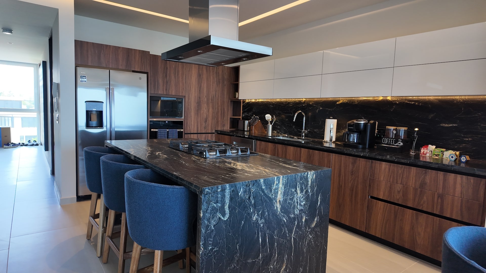 A fully loaded chef's kitchen — 6-burner gas stove, oven, fridge, microwave, island seating for 3, pots & pans, and a stocked spice rack. Everything you need, nothing you don't.